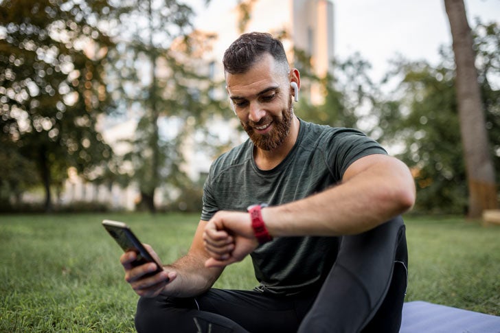 Man using fitness tracker while exercising outside