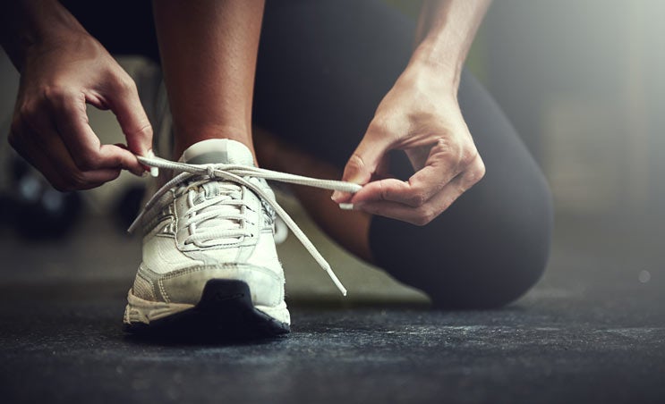Close up of person tying running shoe