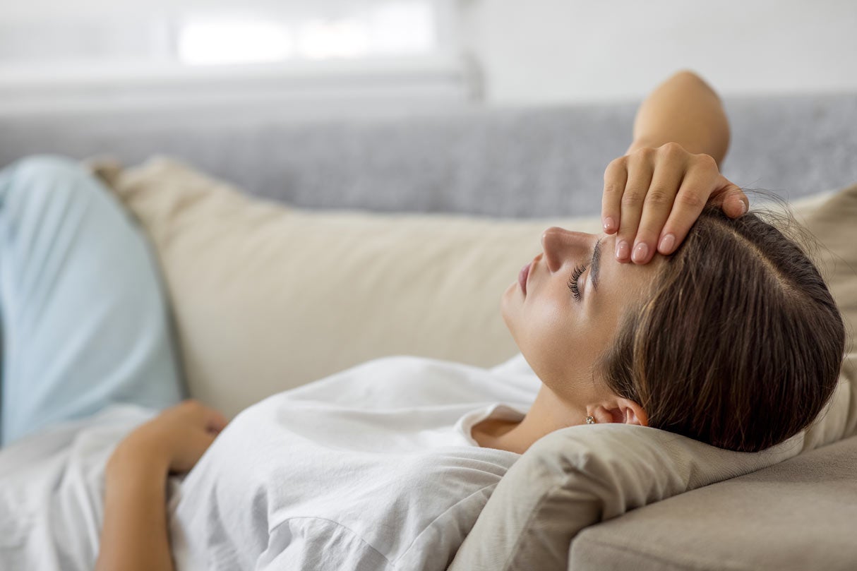 Woman laying on sofa not feeling well
