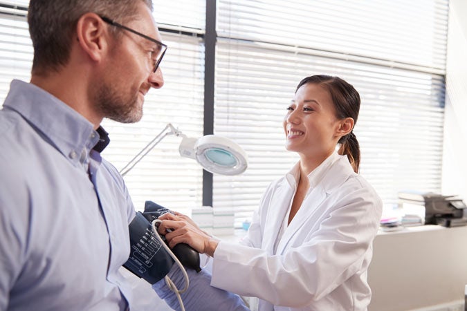 man getting blood pressure taken in office