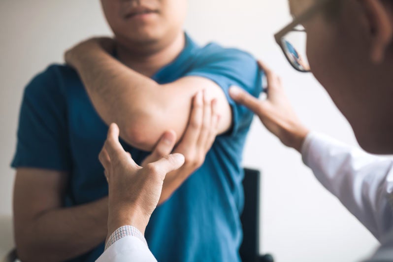 Doctor checks patient's elbow