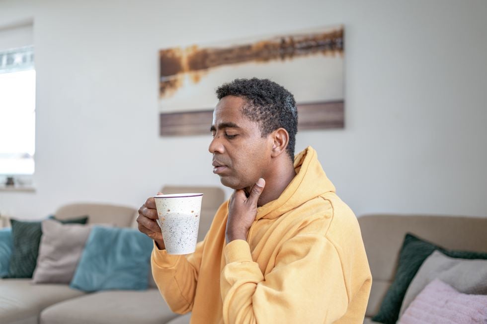 Adult man at home with sore throat