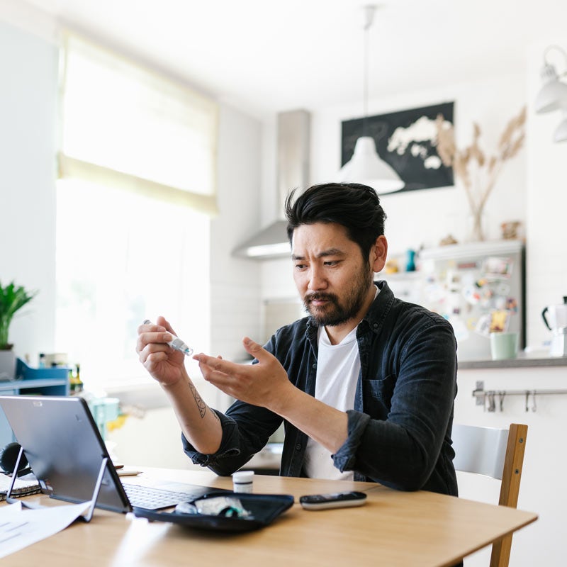Man checking blood sugar in his kitchen